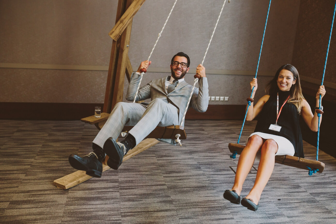 People swinging on swing chairs in the event venue