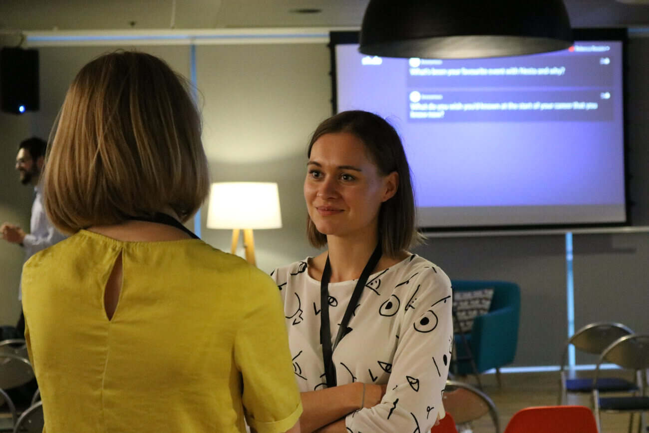 Two women talking during a networking event.