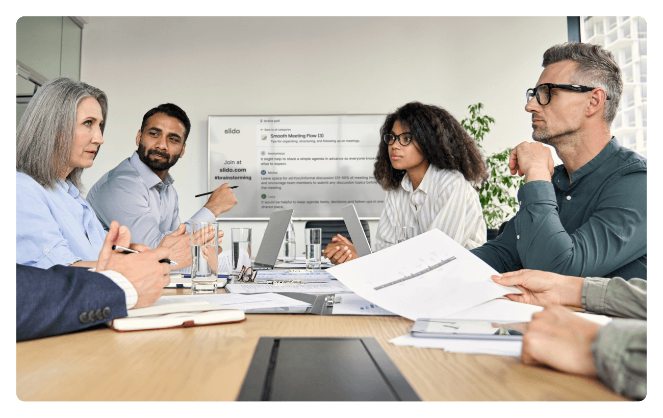 everyone working on their laptops or devices in a meeting