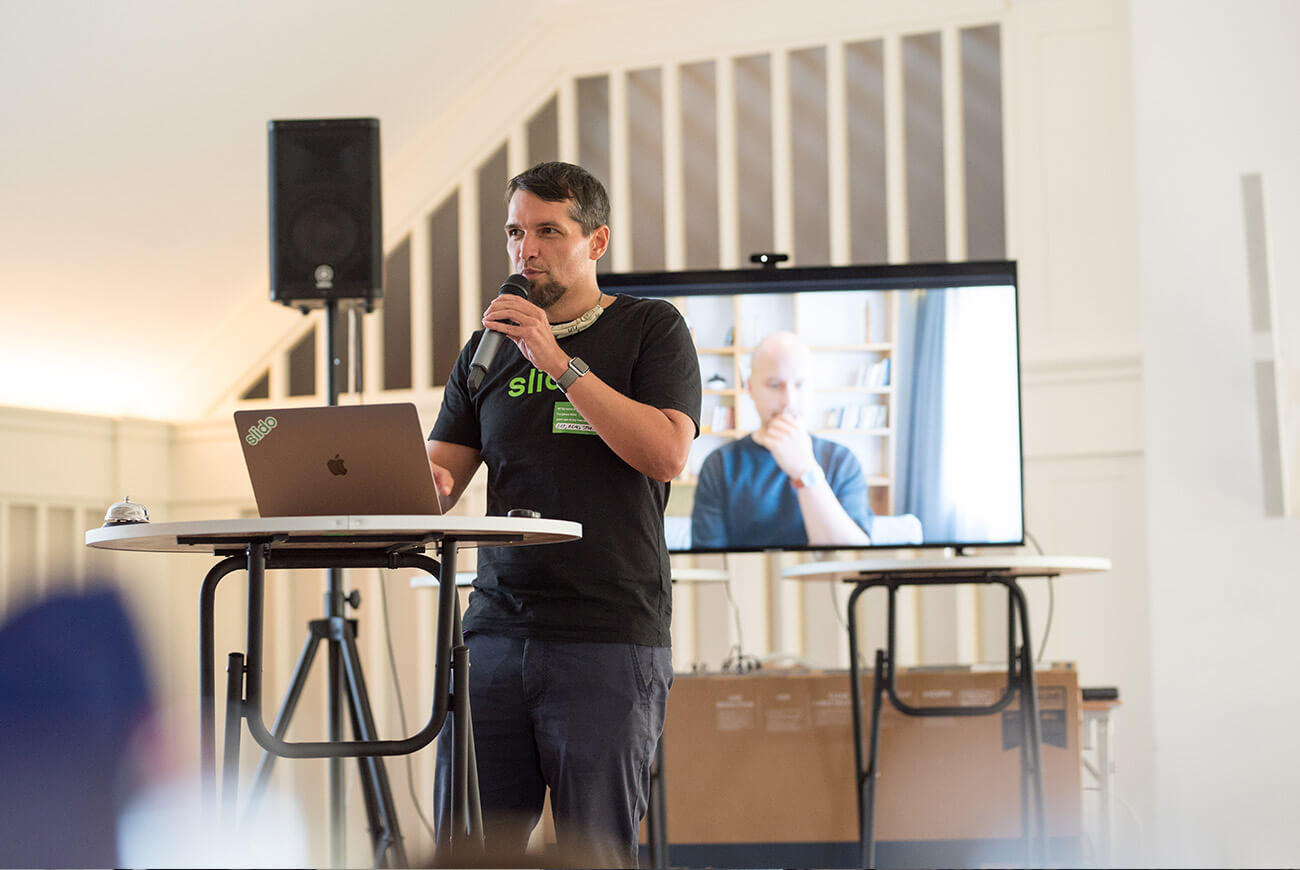A picture of Slido's CEO Peter Komornik giving a speech at a hybrid company offsite