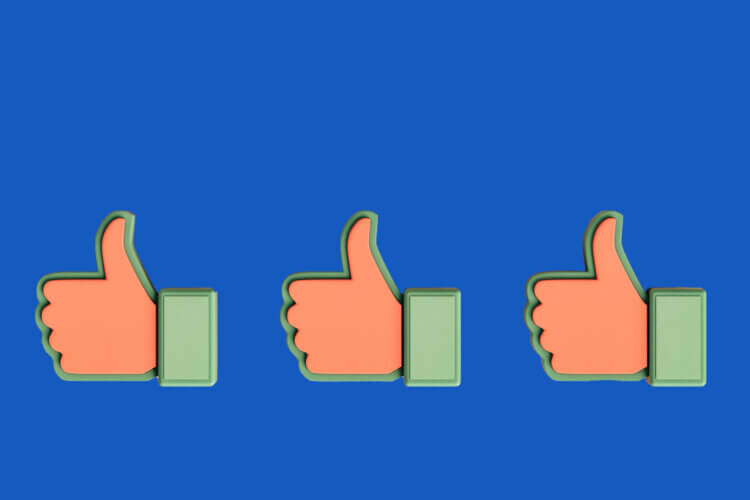 a picture of three thumbs up on a solid blue background used as a header image for a Slido blog post about post meeting feedback surveys